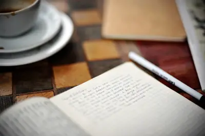 Quaderno, penna e tazza di caffè su un tavolo