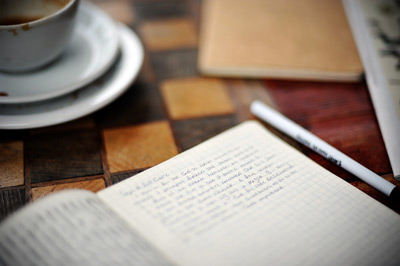 Quaderno, penna e tazza di caffè su un tavolo